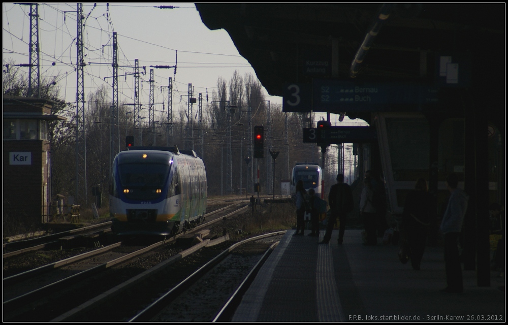 Entlang des Bahnsteigs: NEB VT 643.16 / 643 372 f�hrt an der au�erhalb des Bahnhofs wartenden NE27 nach Wensickendorf vorbei (gesehen Berlin-Karow 26.03.2012)