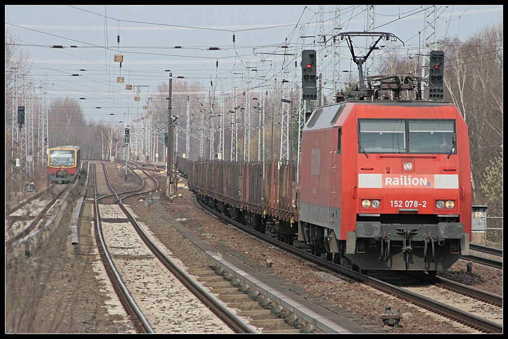 Railion 152 078-2 mit Rungenwagen �berholt vor dem Bahnhof die NEB 27 (DB Schenker Rail Deutschland AG, Berlin Karow 30.03.2010)