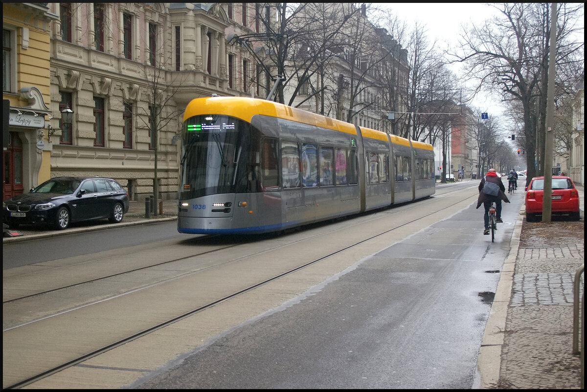 Diesig, Nieselregen und LVB 1038, Typ Solaris Tramino, ist dennoch auf der SL 1 'Mockau, Post' am 22.03.2023 in der Leipziger Käthe-Kollwitz-Straßeim vor Gründerhäusern unterwegs.
