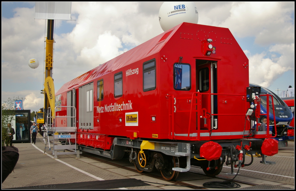 InnoTrans 2016 in Berlin: Bei dem Mannschaftswagen mit Werkstattabteil f�r den Hilfszug der DB Netz Notfalltechnik handelt es sich eigentlich um einen Container, der von der Firma Gf�llner Fahrzeugbau gebaut wird und mit einem Tragwagen geliefert wird. Der Container ist mit zwei Beobachtungsst�nden ausgestattet, bietet Sitzgelegenheiten f�r 6 Personen, Kleiderschr�nke und eine kleine K�chenzeile. An beiden Seiten befinden sich Falttore mit ausschwenkbaren Hilfskr�nen. Das Dieselaggregat ist in der Mitte des Containers untergebracht. Der Werkstattraum bietet Werkzeugschr�nke, Werkbank, Lagerschrank f�r Fl�ssigkeiten, Acetylen und Sauerstoffflaschen (UIC-Nummer D-DB 99 80 9370 038-8 Hilfszugcontainer).