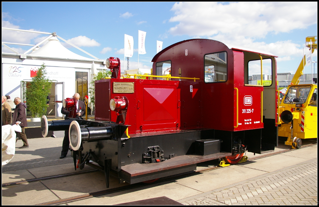 Seit 1889 kann die Firma Windhoff auf Kompetenz in den Bereichen Schienenfahrzeuge, Bahn- und Rangiertechnik zurückschauen. Heute ist die Firma breit aufgestellt und bietet Produkte für Haupt- und Nebenbahnen, Nahverkehr und Metro, Bau und Instandhaltung von Gleisanlagen, Frachttransport, Lösch- und Rettungsfahrzeuge an. Der Oldie DB 311 225-7 stand als Vertreter für Dieselrangierloks von Winhoff auf der InnoTrans 2014 in Berlin auf dem Aussengelände. Ursprünglich wurde die Lok 1936 als Kö 0225 an die DRG ausgeliefert, Ausmusterung erfolgte 1979. Zum DB Museum Nürnberg gelangte die Kleinlok dann 1996
<br><br>
Webseite (deutsch): http://www.windhoff.de/
